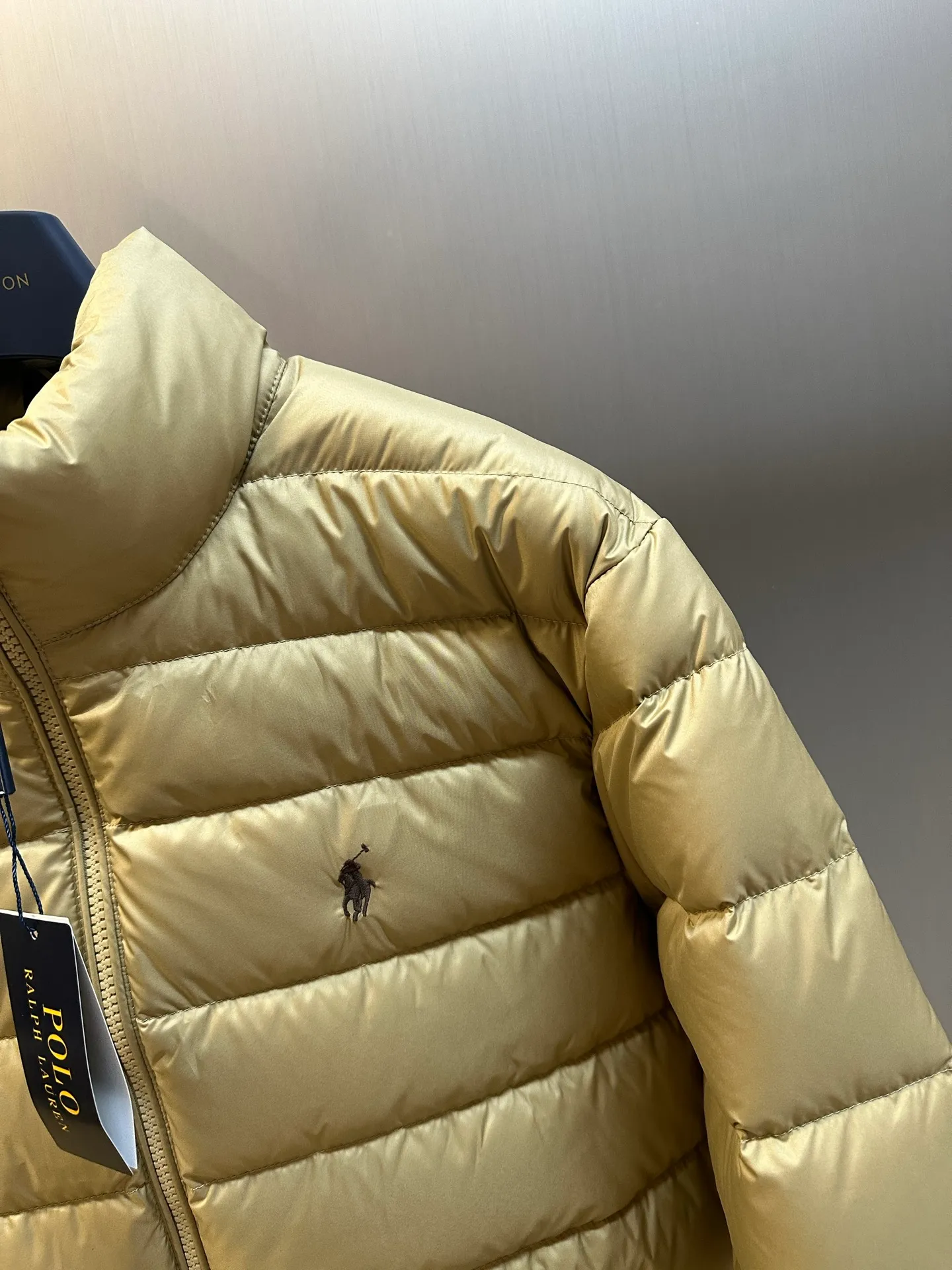 P890 Ralph Lauren lightweight down jacket. The nylon fabric has good windproof and waterproof properties, which can effectively block the intrusion of wind and rain from the outside and keep the inside dry. It is suitable for wearing in humid or rainy environments. The red label on the chest is made with an imported MECLO embroidery machine. The original pattern is scanned first, and then high-quality silk thread is used to make a pattern. The density effect is adjusted by continuous pattern making.  The zipper design is simple and elegant, easy to operate, and the closing design of the cuffs and hem effectively prevents cold wind from invading, improving the warmth and comfort of wearing. It uses 90 white duck down with a weight of 260g to ensure excellent thermal insulation performance. After strict screening and processing, the velvet is not easy to drill, ensuring durability. size: s m l xl